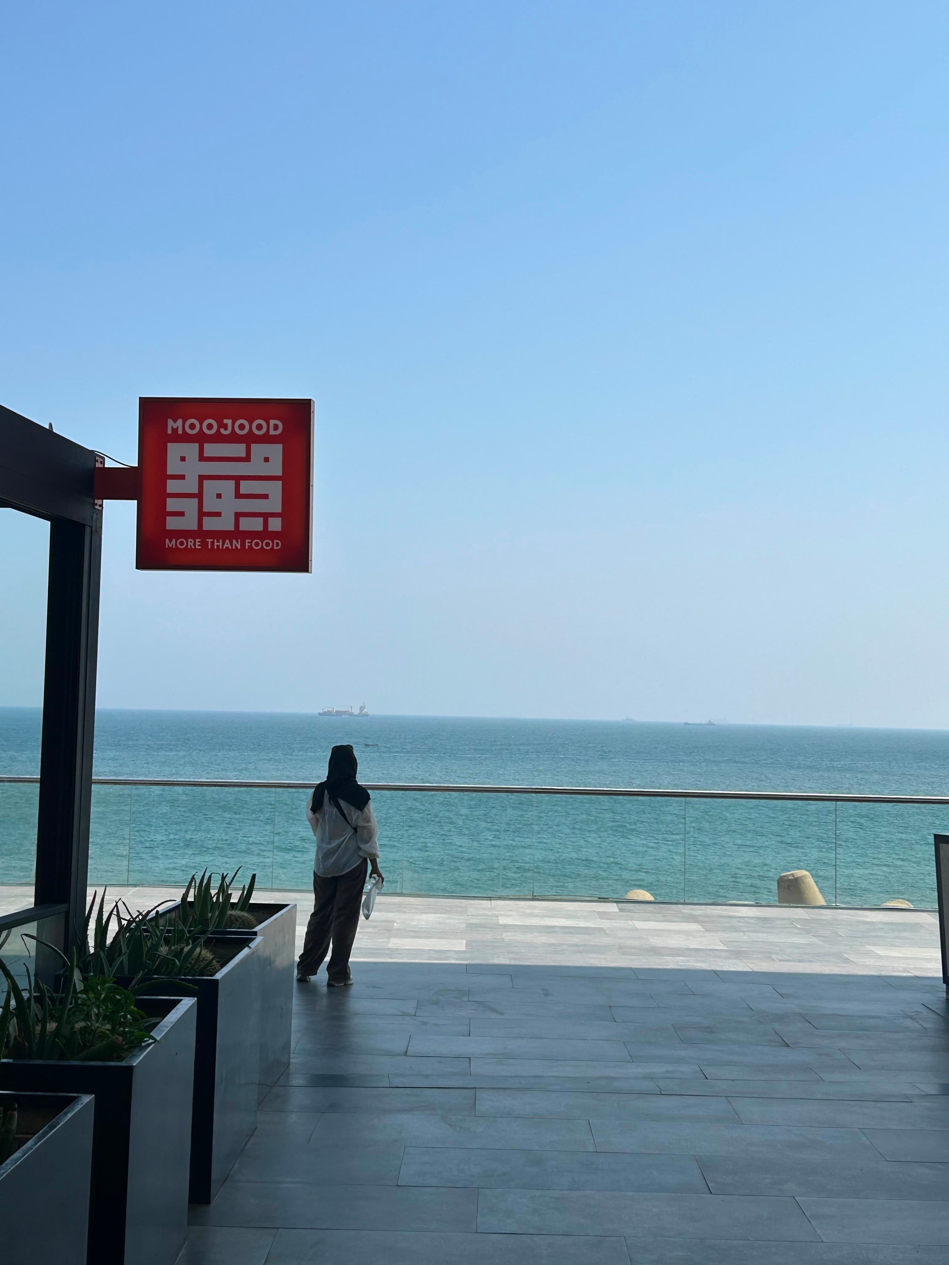 Enseigne Moojood « More than food » sur la terrasse de la Marina, face à l'océan.